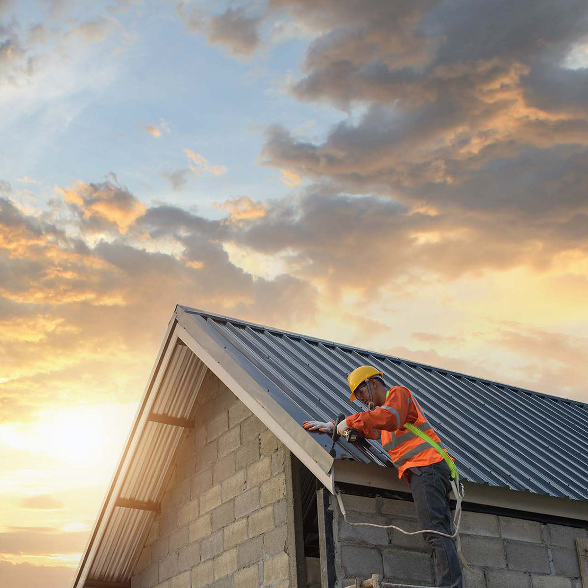 man on roof installing metal roof with hot melt seams