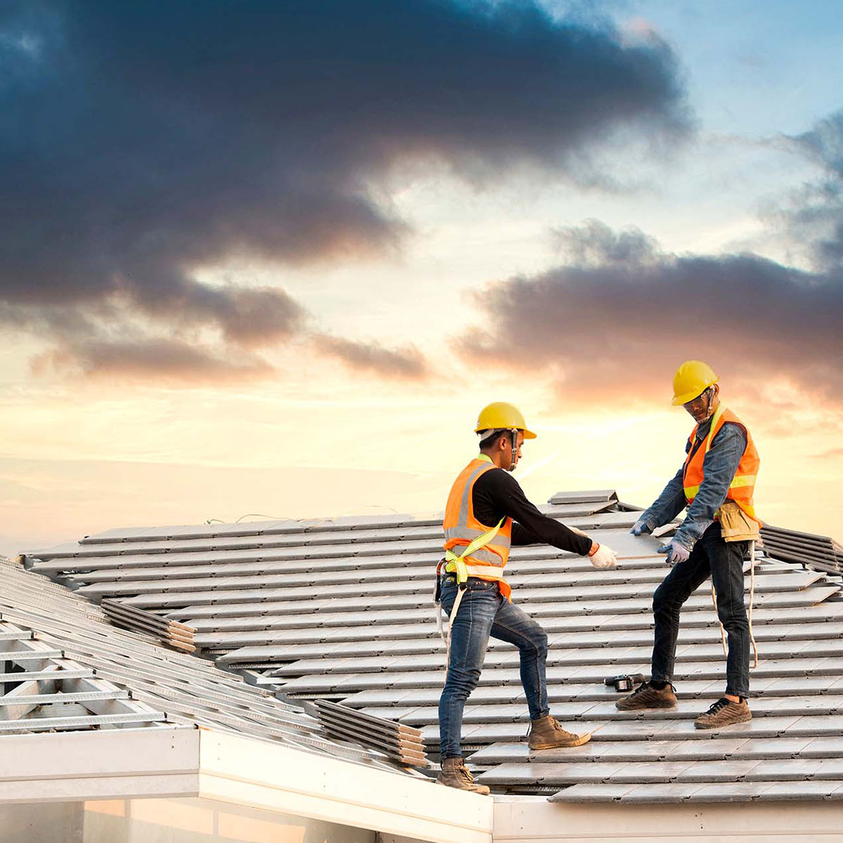 two men on roof installing metal roof with hot melt seams